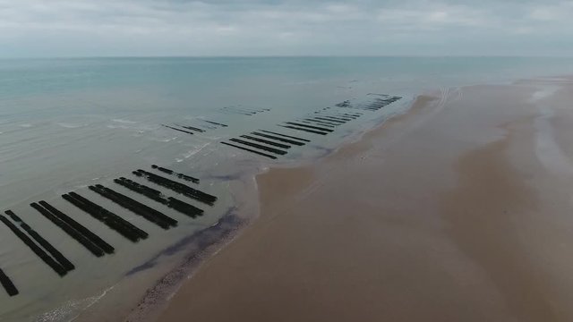 Normandy oyster farm in north sea aerial drone shot cloudy day