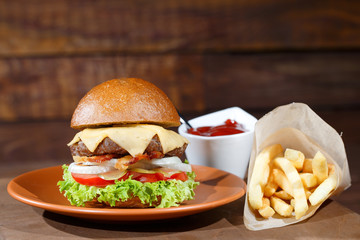 burger and french fries on the wooden table.