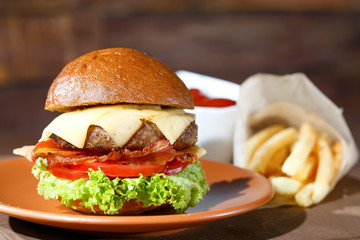burger and french fries on the wooden table.