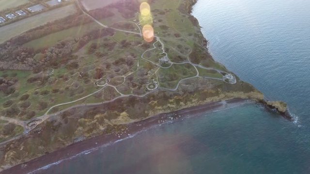 Drone sunset flare over la Pointe du Hoc casemates and shell holes after WW2