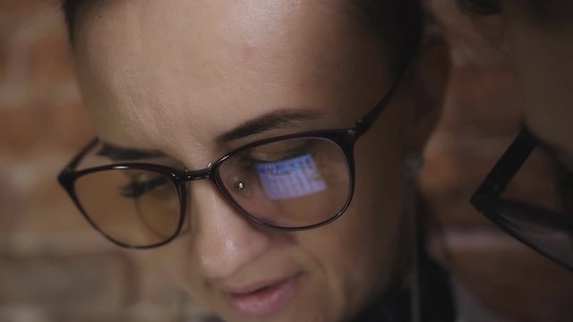 Woman doctor and girl Intern discuss a patient's diagnosis depends on the history on the tablet. Close-up reflection in the glasses.