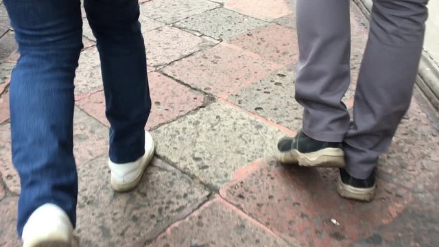 Feet of walking people from behind