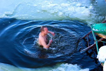 Winter diving in the ice hole in the reservoirs. A man strengthens health by the effects of cold on...