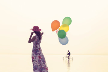 motivation or hope concept, follow your dream and inspiration, girl with balloons at sunset 