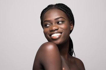 Portrait of Beautiful african woman with dark hair, fresh glowing skin face and bare shoulders...