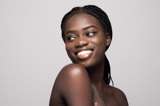 Portrait of Beautiful african woman with dark hair, fresh glowing skin face and bare shoulders isolated on white