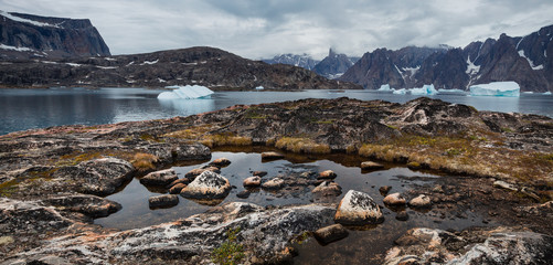 arctic landscape with icebergs among east Greenland fjords
