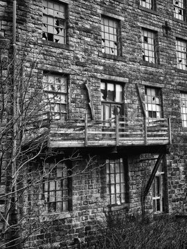 monochrome image of an old abandoned stone factory building