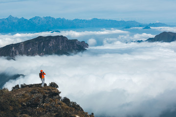 young woman photographer taking photo of  beautiful landscape on mountain peak