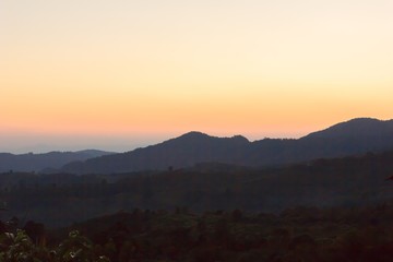 Obraz premium The sun rises behind the mountain in the morning.