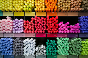 Different rainbow markers or pens on the shelfs at art store.