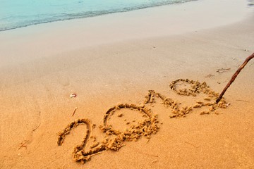 Happy new year concept, 2019 writing on sand beach.