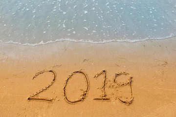 Happy new year concept, 2019 writing on sand beach.