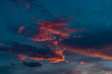 Bright pink sunset clouds on blue sky