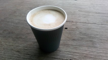 Hot coffee in a glass of gray paper ... Put on a wooden table.