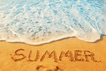 The word of summer writing on sand beach with waves blue ocean.