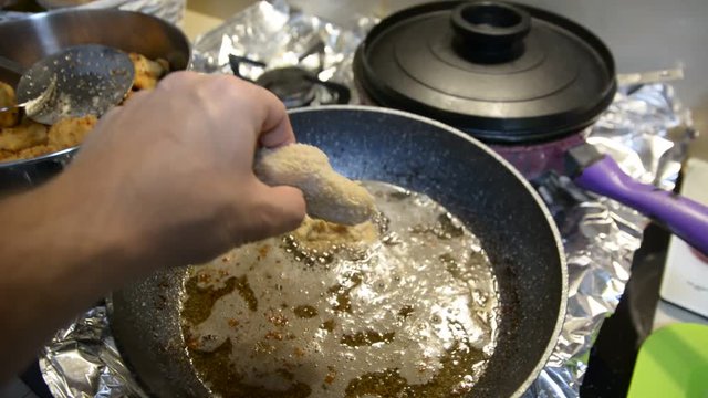 Close up image of chef hand putting chicken nuggets tempura in to hot oil pan for deep fry cooking
