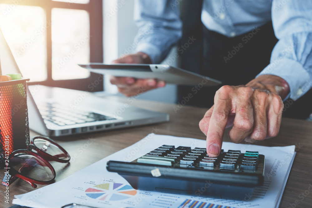 Aufkleber businessman hand working with financial data and calculator and touchpad on desk in modern office.bu