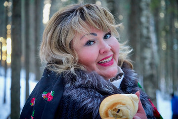 Portrait of beautiful plump woman in a nice winter forest