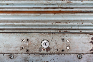 Steel rustic vintage rolling door with keyhole. Rustic shutter door texture. Perfect for background.