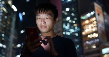 Man work on mobile phone in city at night