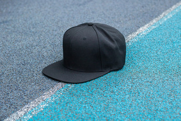 Black snapback hat cap flat visor in outdoor.