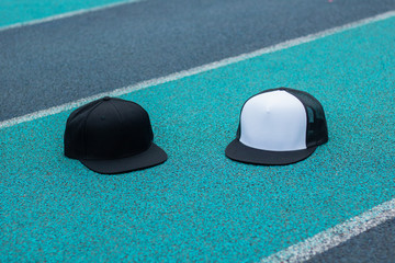 Trucker hat and snapback hat with flat visor black and white color in outdoor.