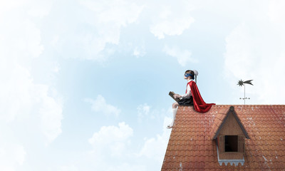 Girl power concept with cute kid guardian against cloudscape bac