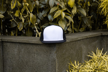 Blank trucker hat cap flat visor with black and white color in outdoor, ready for your mock up...