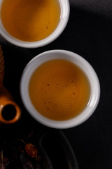The process of brewing tea. Tea ceremony. Cups with a freshly brewed rosehip drink, dark mood.