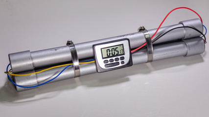 Pipe bomb with an clock timer to trigger detonation on white background