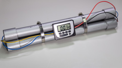 Pipe bomb with an clock timer to trigger detonation on white background