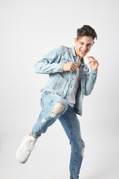 Fummy dark-haired guy dressed in a white t-shirt and a denim jacket ready to fight on the white background in the studio
