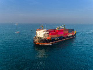 Container ship on the sea port and working crane bridge load full of container for logistics import export, shipping or transportation.