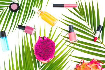 Beauty composition of dragon fruits, palm leaves and cosmetics on white background. Flat lay, top view.