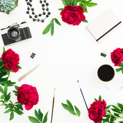 Frame workspace with diary, retro camera, peonies flowers, coffee cup and accessories on white background. Flat lay, top view.