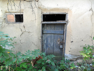 Fototapeta na wymiar Old abandoned clay house door