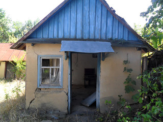 Old abandoned clay house open door
