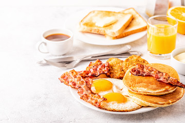 Healthy Full American Breakfast with Eggs Bacon Pancakes and Latkes.