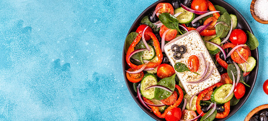 Greek salad of fresh cucumber, tomato, sweet pepper, spinach, red onion, feta cheese and olives