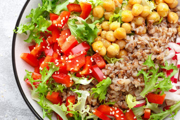 Healthy and delicious bowl with buckwheat and salad of chickpea, fresh pepper and lettuce leaves. Dietary balanced plant-based food. Vegan and vegetarian dish. Top view. Flat lay