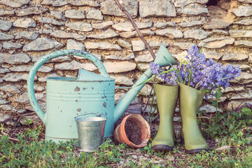Spring gardening concept: old watering can, flower pots and bouquet of blue hyacinth flowers in the rubber boot © stsvirkun