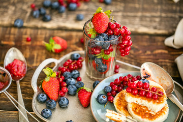 souffle pancake with fresh berry strawberries, blueberries and red currant branch, on a metal tray. healthy breakfast