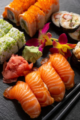 Mix sushi set, on black stone background.