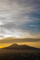 Overview of Naples and its Vesuvius while someone paragliders