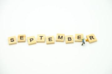 Miniature people Construction worker standing with wood word Month. using as background business concept and calendar concept with copy space  for your text