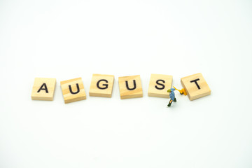 Miniature people Construction worker standing with wood word Month. using as background business concept and calendar concept with copy space  for your text