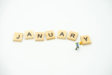 Obraz premium Miniature people Construction worker standing with wood word Month. using as background business concept and calendar concept with copy space for your text