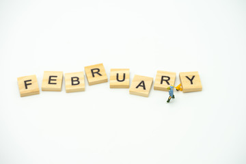 Miniature people Construction worker standing with wood word Month. using as background business concept and calendar concept with copy space  for your text