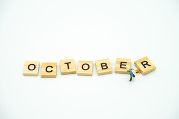 Miniature people Construction worker standing with wood word Month. using as background business concept and calendar concept with copy space  for your text